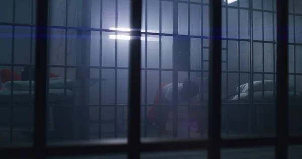 身穿橙色制服的非裔美国囚犯在牢房里做俯卧撑和影子拳击 犯人因在狱中犯罪而服刑 拘留中心或教养所的罪犯 — 图库照片