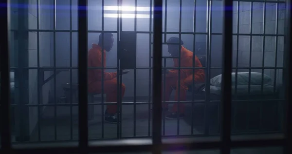 Afroamerykańscy Więźniowie Pomarańczowych Mundurach Siedzą Więziennych Łóżkach Emocjonalnie Rozmawiają Jeden — Zdjęcie stockowe
