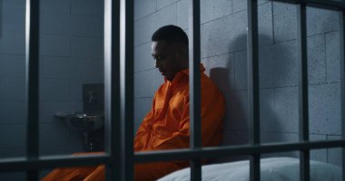 Turuncu üniformalı suçlu Afro-Amerikan adam hapishane yatağında oturup özgürlüğü düşünüyor. Islah evinde ya da gözaltı merkezinde kasvetli bir suçlu. Mahkûm, hapis cezasına çarptırıldı.