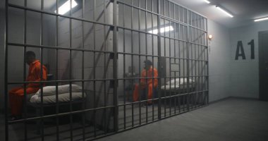 Afro-Amerikalı mahkumlar ıslahevinde ya da cezaevinde. Turuncu üniformalı bunalımlı bir adam hapishane yatağında oturur ve parmaklıklı pencereye bakar. Mahkumlar hapis cezasına çarptırıldı.