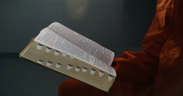 聖書のクローズアップショット アフリカ系アメリカ人の囚人は本を手に持ち 読んだり ページを飛び越えたりする 男性犯罪者 犯罪者は刑務所で犯罪の刑期を務めています 刑務所や拘置所 — ストック写真