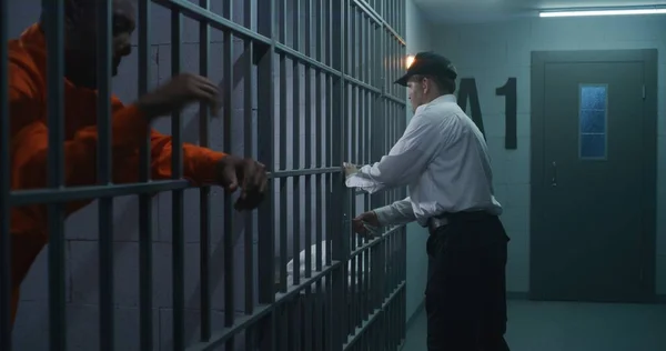 ウォーデンは刑務所に新しい囚人を連れて来て 手錠を外した アフリカ系アメリカ人犯罪者は 矯正施設や拘置所で投獄期間を定めている 刑務所で有罪となった殺人犯 — ストック写真