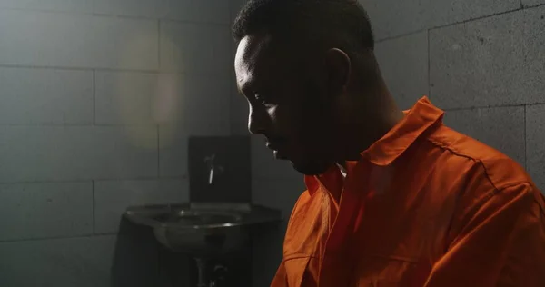 African American Prisoner Orange Uniform Reads Bible Prison Cell Turns — Stock Photo, Image