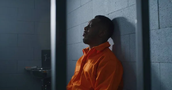 Schuldiger Afroamerikaner Orangefarbener Uniform Sitzt Auf Dem Gefängnisbett Und Denkt — Stockfoto