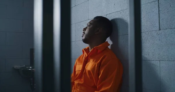 Ένοχος Αφροαμερικανός Πορτοκαλί Στολή Κάθεται Στο Κρεβάτι Της Φυλακής Και — Φωτογραφία Αρχείου