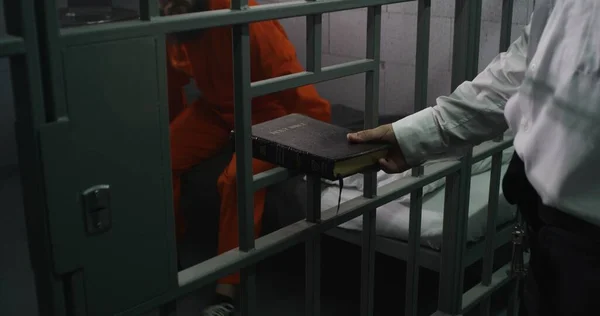 Gefängnisbeamter Übergibt Bibel Männliche Häftlinge Orangefarbener Uniform Verbrecher Sitzt Auf — Stockfoto