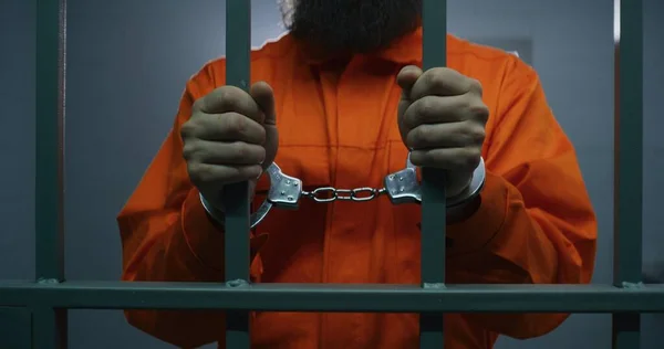 Muž Oranžové Uniformě Poutech Drží Kovové Mříže Stojí Vězeňské Cele — Stock fotografie