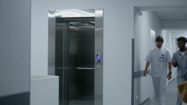 아프리카계 미국인 의사는 동료와 올리고 버튼을 누릅니다 의료진은 복도에서 엘리베이터를 — 비디오