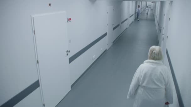医院走廊 专业医生 行走的护士 成熟的医生用钥匙卡开门 走进橱柜 在诊所或医疗设施的医务人员和病人 高角度 — 图库视频影像