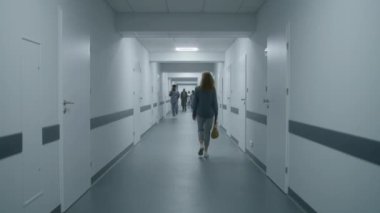Kadın hastane koridoruna gidiyor ve doktordan kabineye geçmesini istiyor. Hemşire ve yaşlı hasta klinik koridorunda yürür ve test sonuçlarını tartışırlar. Klinikte çok ırklı tıbbi personel var. Statik çekim. Arka plan.