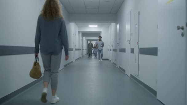 Kvinnan Går Till Sjukhuskorridoren Och Frågar Doktorn Vägen Till Kabinettet — Stockvideo