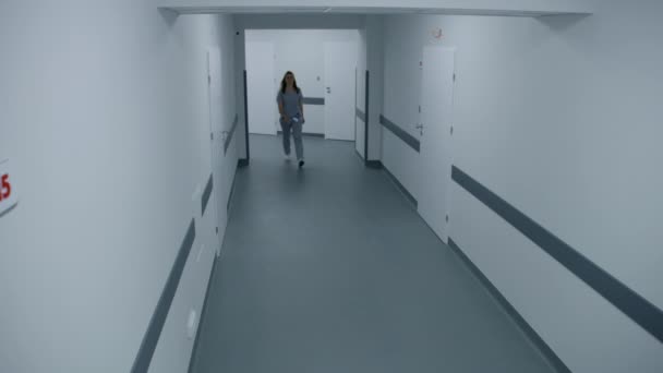 明るい病院の廊下 専門医 看護師 多様な患者が歩いている 医療従事者は現代の診療所や医療施設で働いています セキュリティカメラビュー 高角度 — ストック動画