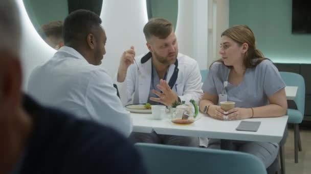 Médicos Multiculturais Sentam Café Clínica Moderna Médicos Profissionais Conversam Enquanto — Vídeo de Stock