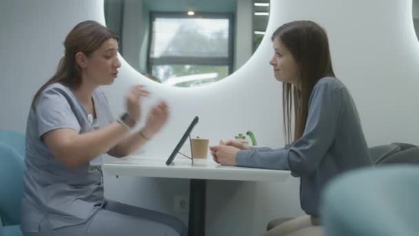 Kvinnlig Läkare Sitter Kliniken Café Med Patient Använder Digitala Surfplatta — Stockvideo