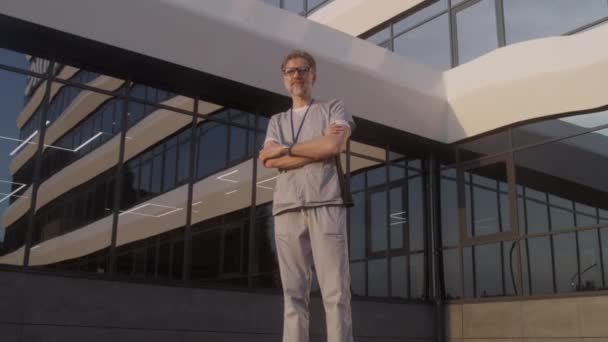 Gammal Läkare Uniform Står Utomhus Nära Det Moderna Sjukhuset Professionell — Stockvideo