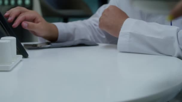 专业医生坐在诊所咖啡店 在数码平板电脑上检查测试结果 卡布瑞亚的工人带晚餐到医务室 医护人员在医院或医疗中心餐厅用餐 — 图库视频影像