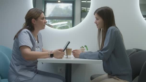 의사는 환자와 클리닉 카페에 디지털 태블릿 컴퓨터를 사용합니다 전문가가 여성에게 — 비디오