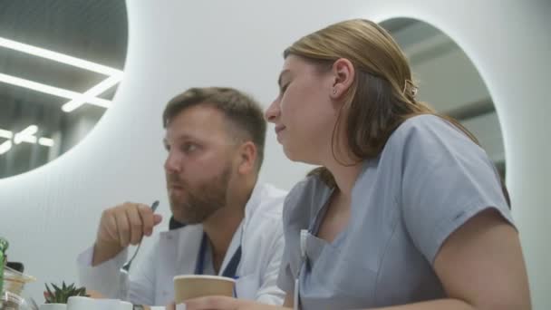 Άντρας Γιατρός Και Νοσοκόμα Κάθονται Στη Σύγχρονη Κλινική Καφέ Επαγγελματίες — Αρχείο Βίντεο