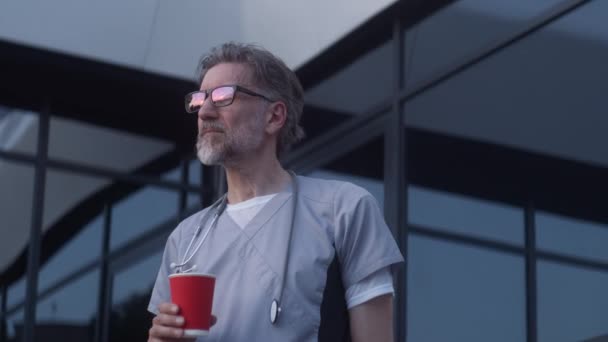 Starší Lékař Brýlích Uniformě Stojí Večer Vchodu Kliniku Profesionální Zdravotník — Stock video
