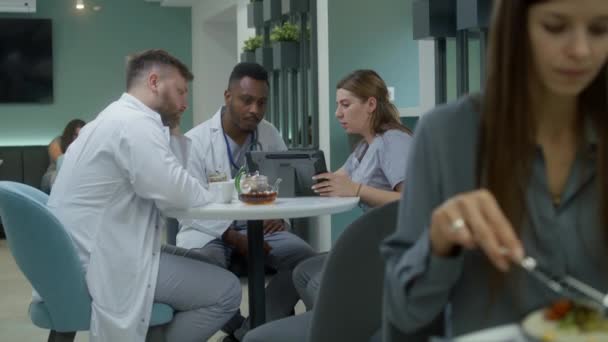 Πολυπολιτισμικοί Γιατροί Κάθονται Κλινική Καφέ Χρησιμοποιούν Ψηφιακή Ταμπλέτα Ειδικοί Υγείας — Αρχείο Βίντεο