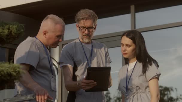 Doctors Uniform Stand Outdoors Hospital Entrance Professional Medics Discuss Diagnoses — Stock Video