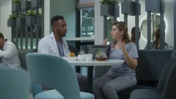 Female Doctor Sits Modern Clinic Cafe African American Colleague Uses — Stock Video