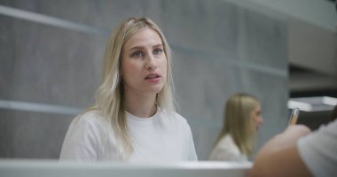 Bayan yönetici, klinik lobisindeki resepsiyonda hastayla konuşuyor. Kadın danışman, tıbbi test sonuçları veriyor. Tıp personeli modern tıp merkezinde çalışıyor. Sağlık hizmetleri. Portre.