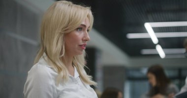 Kadın resepsiyonist, klinik lobisindeki resepsiyonda hastayla konuşuyor. Kadın danışman, tıbbi test sonuçları veriyor. Tıp personeli modern tıp merkezinde çalışıyor. Sağlık hizmetleri. Portre.