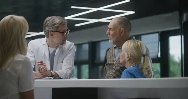 Tıp Merkezinin Bekleme Odasındaki Resepsiyonun Yanında Duran Yaşlı Çift Doktordan — Stok fotoğraf