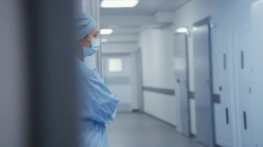 Doktorlar diğer sağlık görevlileri için ameliyat kapılarını açarlar. Çok kültürlü cerrahlar yaşlı hastaları ameliyata alırlar. Yaşlı adam nabız oksimetresiyle sedyede yatıyor ve damlaların altında. Tıbbi personel hayat kurtarıyor..
