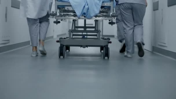 医生和医护人员把严重受伤的病人的骨科转移到手术室 医疗拯救了人的生命 靠近医护人员的腿 明亮的医疗设施走廊 紧急部门 — 图库视频影像