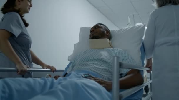 Vrouwelijke Dokters Vervoeren Afro Amerikaanse Patiënten Door Kliniek Gang Middelbare — Stockvideo