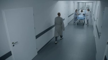 Kadın doktor ve hemşire sedyede Afro-Amerikalı bir hastayla hastane koridorunda duruyor. Profesyonel sağlık görevlileri ameliyathaneye nakledilecek. Güvenlik kamerası görüntüsü. Gözetim sistemi.