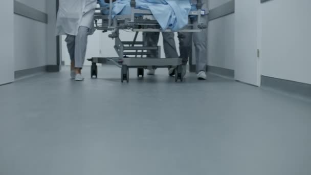 医生和护士把严重受伤病人的担架推向手术室 医疗拯救了人的生命 靠近医护人员的腿 明亮的医疗设施走廊 紧急部门 — 图库视频影像