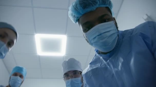 複数の医師が手術前に患者の状態を確認する アフリカ系アメリカ人の外科医が患者と話し 呼吸管を置く 医学は患者を手術室に搬送する 職場の医療スタッフ — ストック動画
