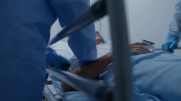 老人躺在格尔内 在医疗设施走廊里滴着药水 医生检查重症病人并测量他的血压 人事紧急部门 慢动作靠近点 — 图库视频影像