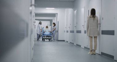 Kadın sıhhiyeciler Afrikalı Amerikalıları klinik koridorundan taşıyorlar. Erkek doktor iş arkadaşlarına gelir ve yaralı hastaların taşınmasına yardım eder. Orta yaşlı bir adam sedyede yatıyor ve hemşireyle konuşuyor..