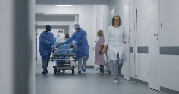 Lekarze Pielęgniarki Biegają Pchają Wózek Ciężko Rannym Pacjentem Salę Operacyjną — Zdjęcie stockowe