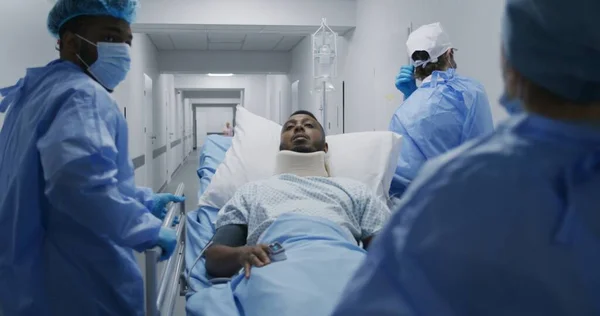 Lääkärit Ensihoitajat Työntävät Paarit Potilaan Kanssa Leikkaussaliin Afroamerikkalainen Mies Jolla — kuvapankkivalokuva