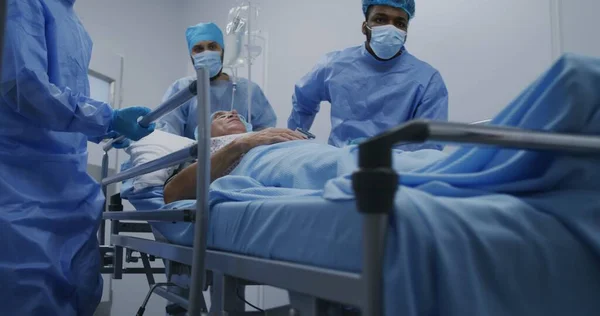 Çok Irklı Cerrahlar Yalancı Yaşlı Bir Adamı Ameliyat Odasından Sedye — Stok fotoğraf