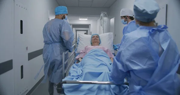 Lekarze Pielęgniarki Sanitariusze Pchają Nosze Chorym Pacjentem Salę Operacyjną Starsza — Zdjęcie stockowe