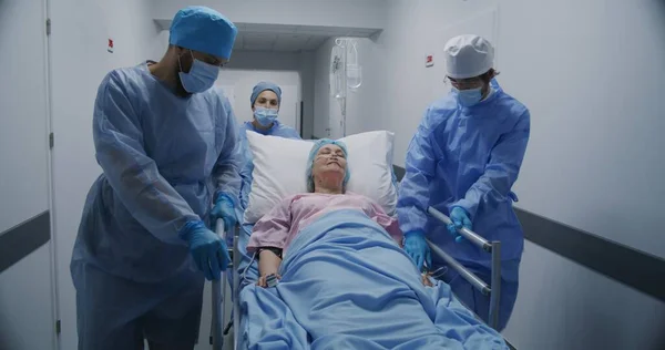 의사와 구급대원들은 구르니를 노인과 밀어붙이고 그녀와 이야기합니다 의사는 환자의 심박수 — 스톡 사진
