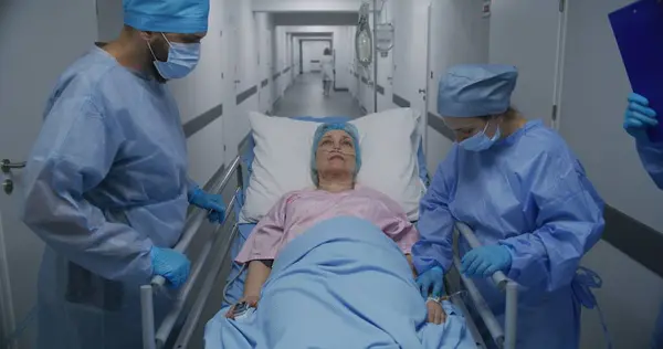 Médicos Enfermeras Paramédicos Examinan Una Anciana Enferma Corredor Las Instalaciones — Foto de Stock