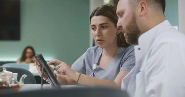 Kadın Doktor Erkek Meslektaşıyla Birlikte Modern Klinik Kafesinde Oturuyor Dijital — Stok fotoğraf