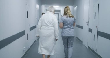 Female doctor, nurse with digital tablet walks along the clinic corridor with elderly woman, helps patient to get to hospital ward after procedures. Medical staff, patients in medical center hallway. clipart