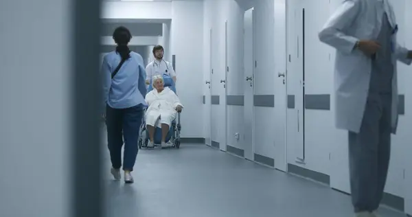 Médico Empurra Cadeira Rodas Com Paciente Sexo Feminino Caminhando Longo — Fotografia de Stock