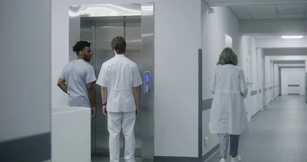 아프리카계 미국인 의사는 동료와 올리고 버튼을 누릅니다 의료진은 복도에서 엘리베이터를 — 스톡 사진