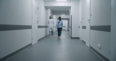 Profesyonel doktorlar yaşlı hastaları tekerlekli sandalyeyle sağlık odasına götürüp test sonuçlarını tartışırlar. Olgun doktor, meslektaşı ve kıdemli bayan için kapıyı açar. Tıbbi personel iş başında..