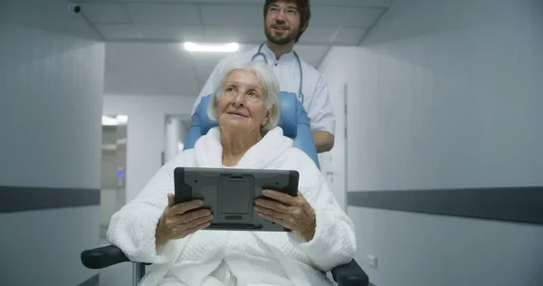 Starší Žena Podívá Výsledky Lékařských Testů Digitálním Tabletu Prodiskutuje Mladým — Stock fotografie