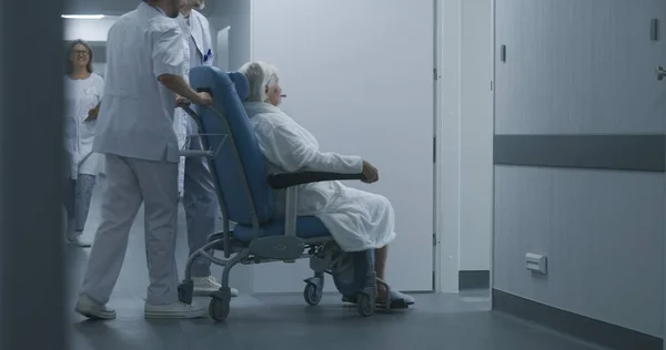 Lékaři Odvádějí Starší Ženu Operačního Sálu Nebo Ordinace Invalidním Vozíku — Stock fotografie